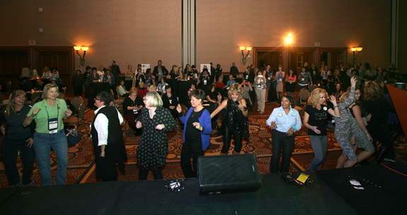 Women at the conference dancing on a dance floor at the networking reception.