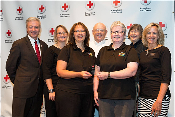 Site Bloodmobile Committee Chairperson Donna Dewanz (center left) accepts the American Red North Central Blood Services Region’s Outstanding Blood Drive Sponsor Award from Phil Hansen, regional CEO, American Red Cross Minnesota Region (left) and Kerry Cipra, account manager, American Red Cross North Central Blood Services (center right). Dewanz is joined on stage by (from second left) Tami Murphy, Sleepy Eye Site Manager Warren Harris and Betty Jensen.