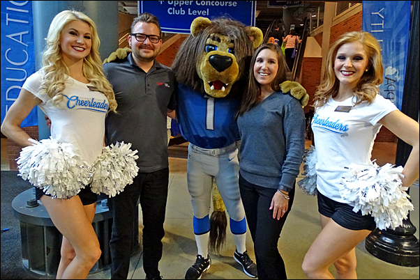 tefanie Poe and Cody Miller from SAGE get a photo with Detroit Lions' cheerleaders and the team's mascot, ROARY.