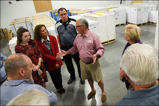 Tom Metz, CEO and president of TradeNet (center), leads a tour of the supplier’s factory. 