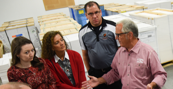 Tom Mertz, CEO and president of TradeNet (right), leads a tour of the supplier’s factory.