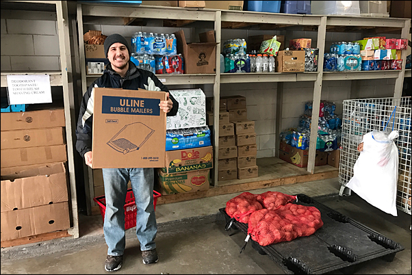 Halls & Company's Zach Zinder helps unload the supplier's food donation to North-Suburban Emergency Assistance Response.
