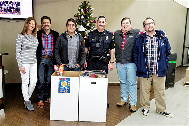 Sgt. Brian Morales (center) of the Irving Police Department visited PPAI headquarters on Friday to collect the more than $1,600 in toys and funds staff had donated to the Irving Police and Fire Blue Christmas Organization and meet with Association staff.