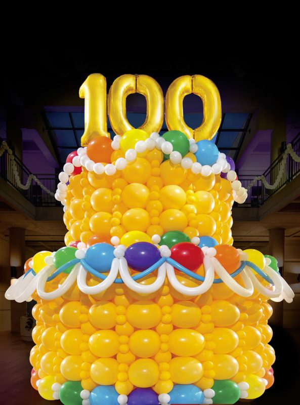 This is a large cake made out of balloons with the number 100 made out of balloons at the top.